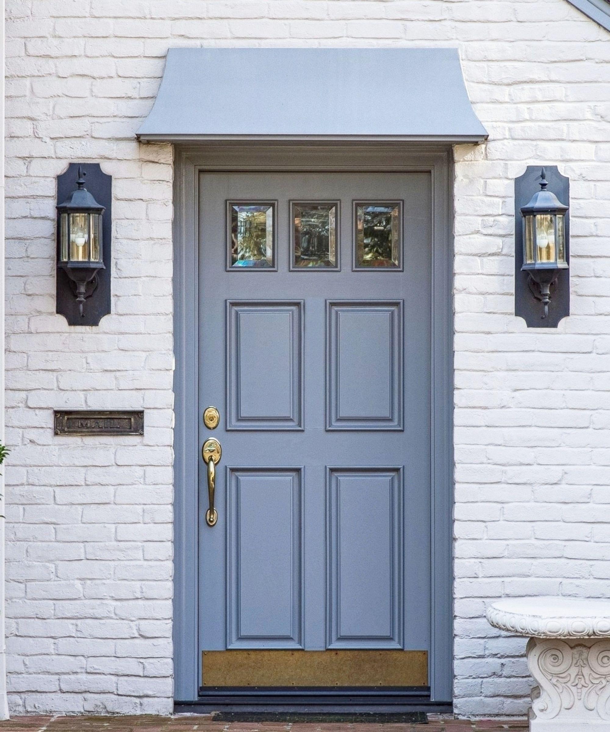 Front door with blue awning and brass fixtures